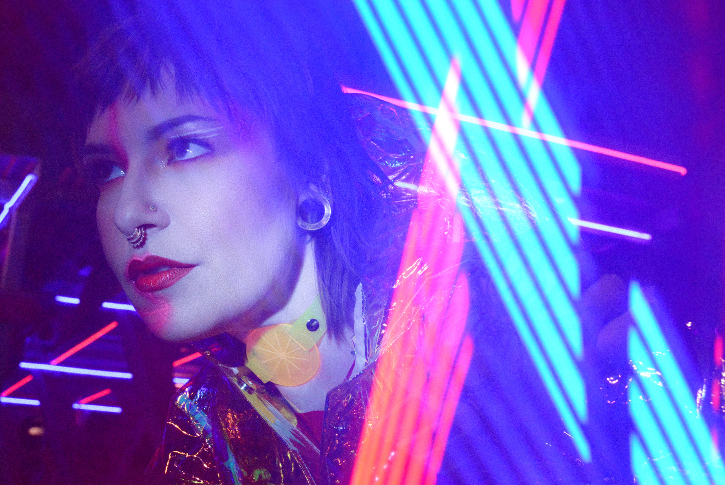 Katrina models a neon uv yellow choker by Apatico and Anhedonie under blue and red neon lights at night.