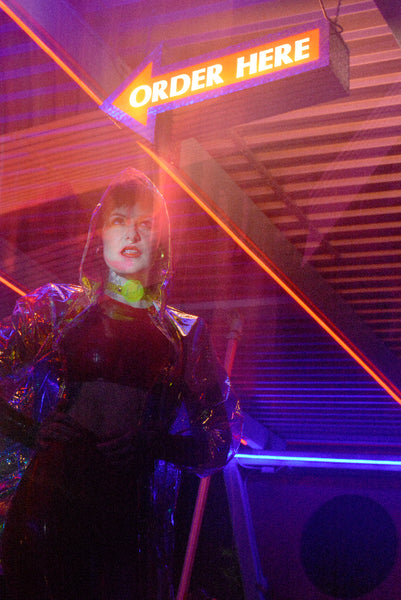 Katrina models a neon uv green choker by Apatico and Anhedonie under blue and red neon lights at night.