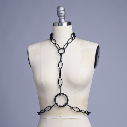Black cathedral chain body harness belt displayed on a dress form.
