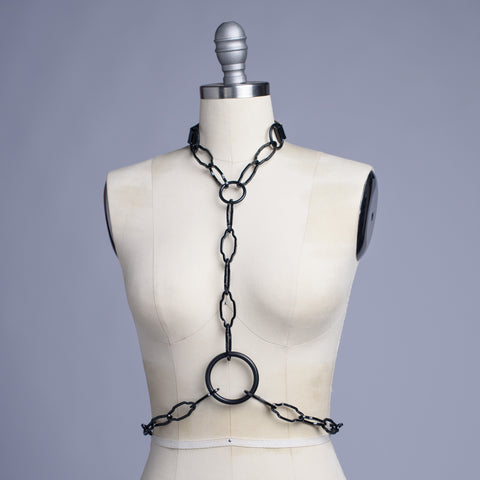 Black cathedral chain body harness belt displayed on a dress form.