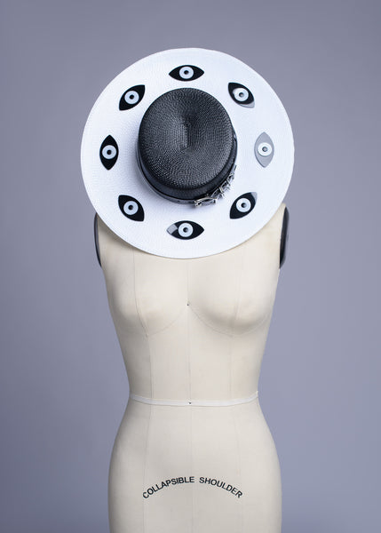 Apatico harness hat with wide brim. Black and white two-tone faux strap. Eyeball design all around the brim.