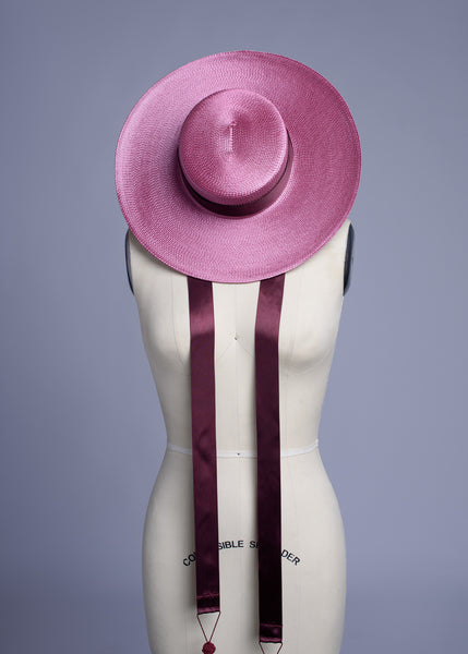 Apatico dusty mauve pink wide brim straw hat with burgundy satin ribbon ties and tassels.