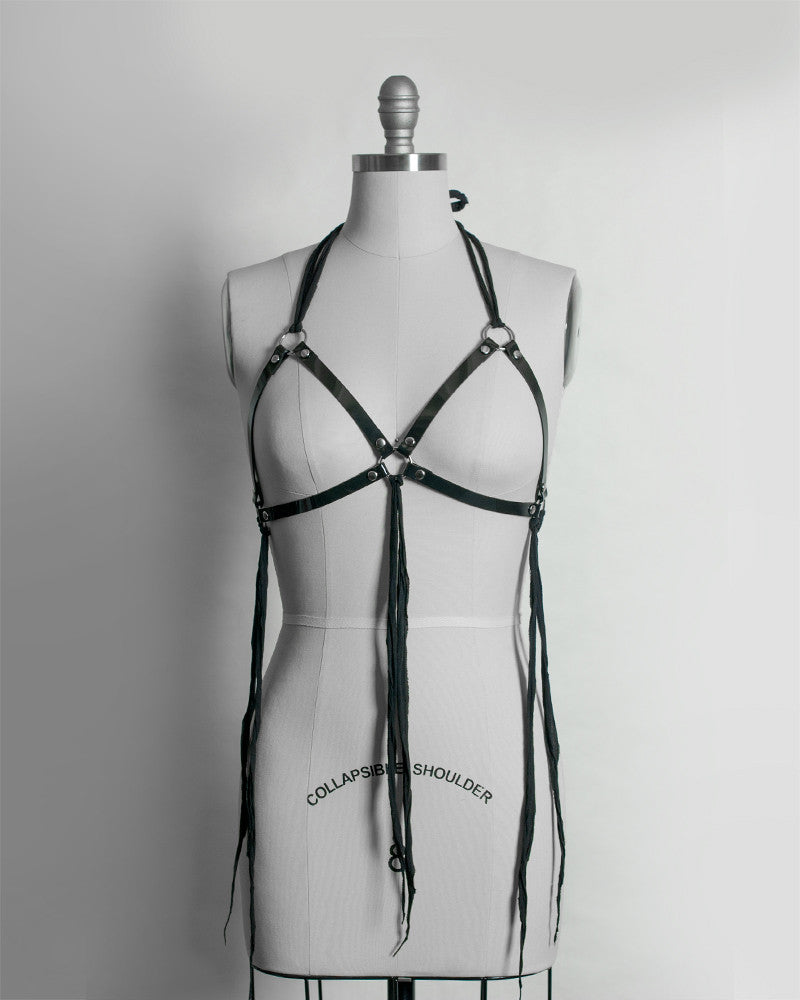 https://www.apatico.net/cdn/shop/products/post-apocalyptic-harness-cage-bra-pvc-vinyl-black-shredded-gauze-wraith-gothic-nugoth-dystopian-occult-fashion-halter-top-front_1024x1024.jpg?v=1469406083